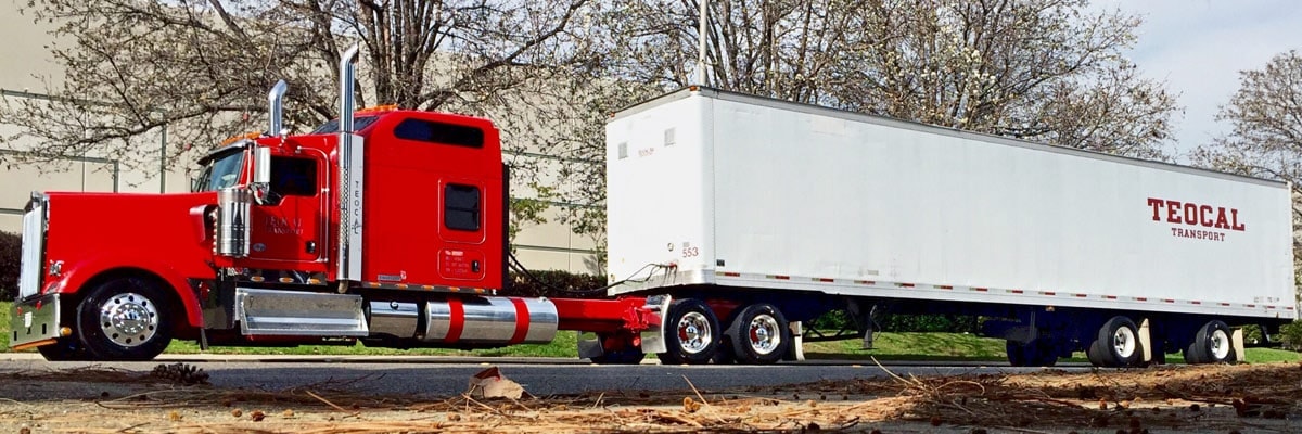 A red semi truck is parked in front of a building in California.